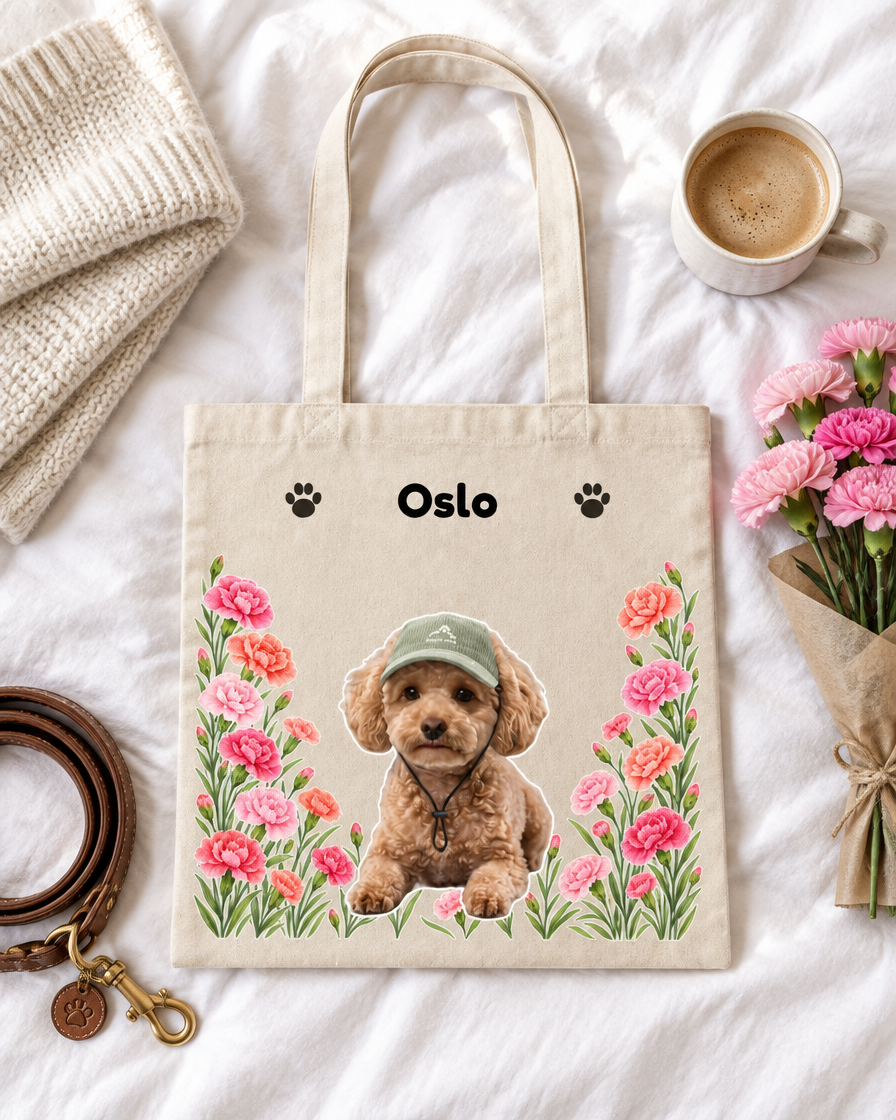Tote bag personnalisé avec prénom et fleurs de naissance posé sur un lit